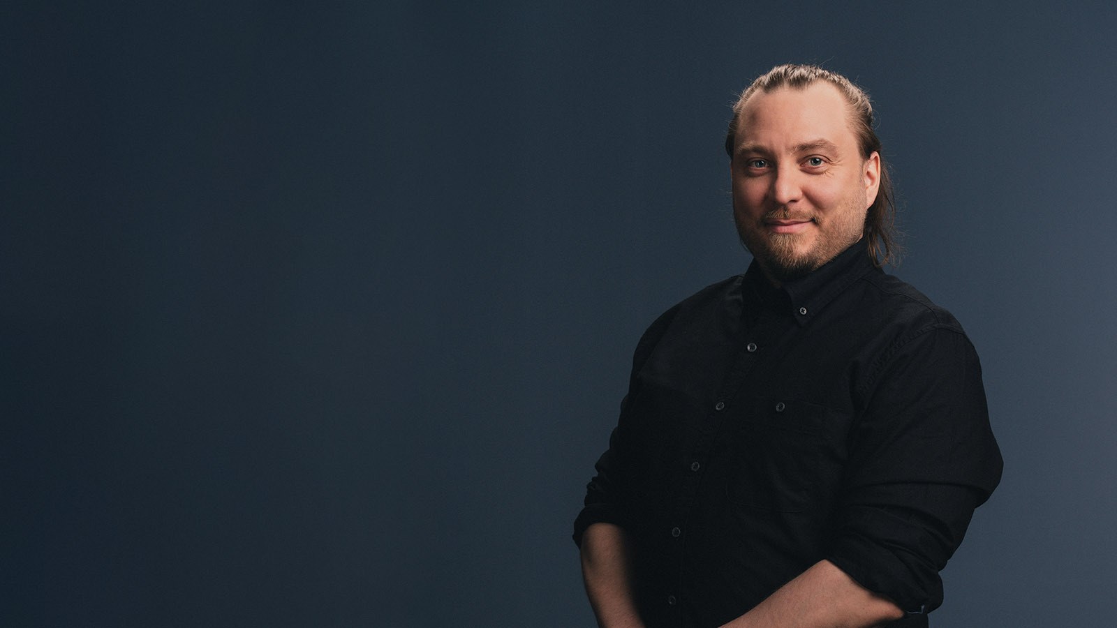 Luma Creativen asiantuntijakuva, jossa hymyilevä mies poseeraa tummansinistä taustaa vasten. Kuva viestii lähestyttävyyttä ja ammattitaitoa markkinointiyhteistyön aloittamista käsittelevässä blogiartikkelissa.
