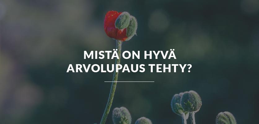 Luma Creativen blogiartikkelin pääkuva, jossa on tummanpuhuva ja pehmeä tausta luonnon helmasta. Kuvassa on punainen kukan nuppu ja sen päällä selkeä valkoinen otsikkoteksti "MISTÄ ON HYVÄ ARVOLUPAUS TEHTY?".