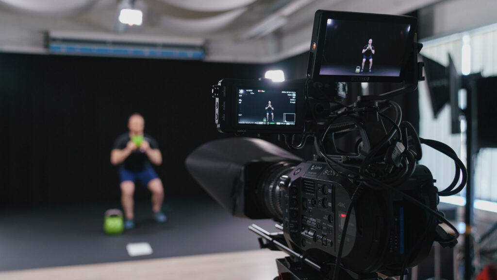 Luma Creativen blogiartikkelin pääkuva, joka on otettu videokuvauksen takaa studiossa. Kuva visualisoi videotuotannon teknistä toteutusta, kalustoa ja studiotyöskentelyä, jotka ovat keskeisiä tekijöitä videotuotannon hinnan muodostumisessa.